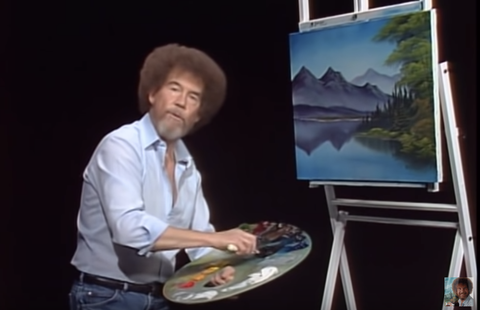 Bob Ross with a painting of mountains