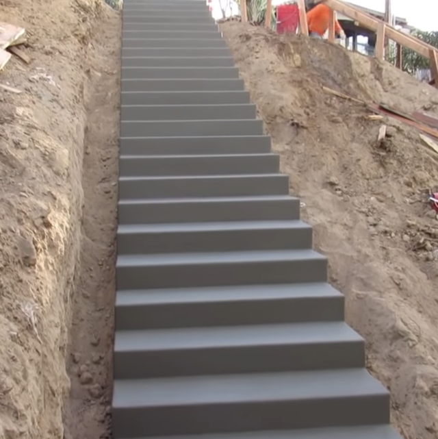 an image of a tall concrete staircase on the side of a hill