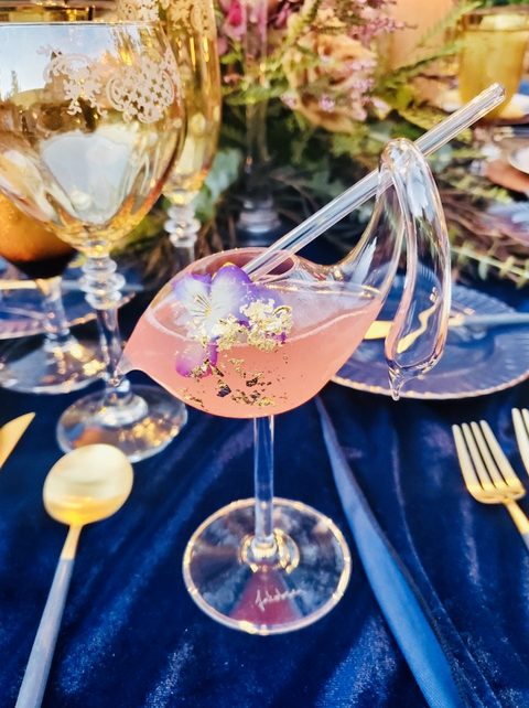 pink cocktail with flower and gold leaf