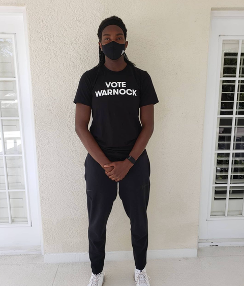 wnba star elizabeth williams wearing a "vote warnock" t shirt