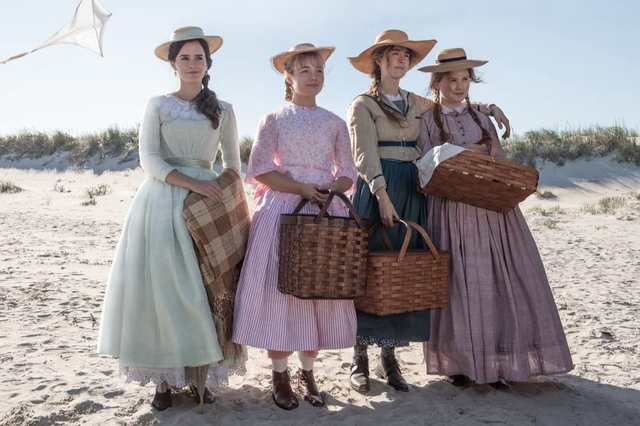 from left to right, emma watson, florence pugh, saoirse ronan, and eliza scanlen, four white actresses, in a still from little women where they are standing on a beach in 1800s clothing