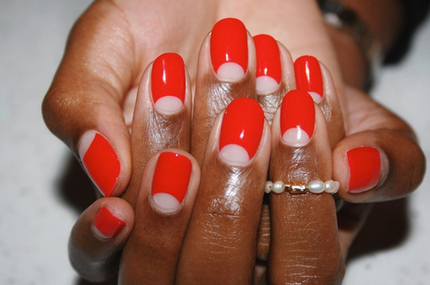 a manicure that features scarlet curves with a pearl ring