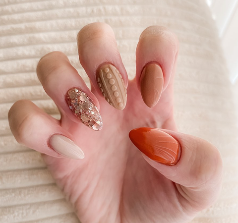 textured beige and orange nail art