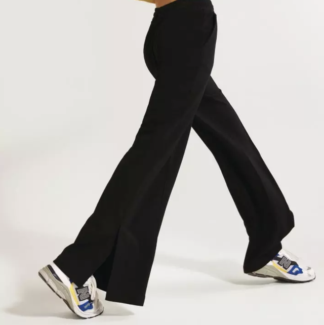 a model wears a pair of flare leggings by sweaty betty with new balance sneakers in a roundup of the best flare leggings 2022