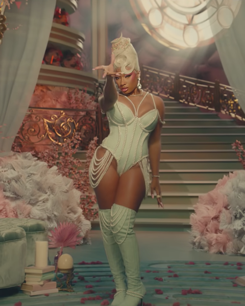 megan thee stallion wears a white wig and baby blue corset in front of ornate staircase