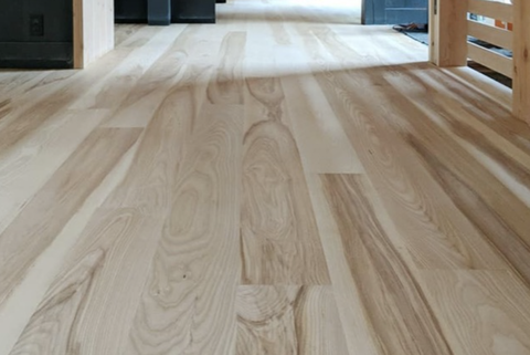 a hardwood floor made of wide ash planks