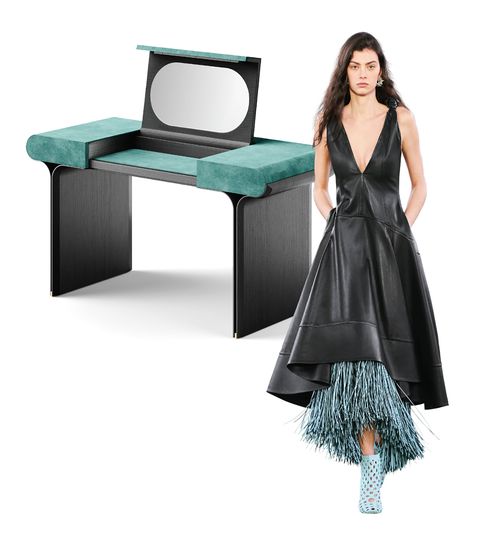 dark vanity with popup mirror and green sides and a model next to it with a long black leather dress with slate colored fringe peeking out from the bottom over trellis design booties
