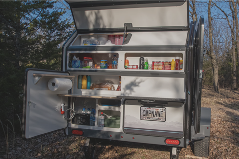 campinawe campine trailer back end with storage cubbies and a rollout cook stove