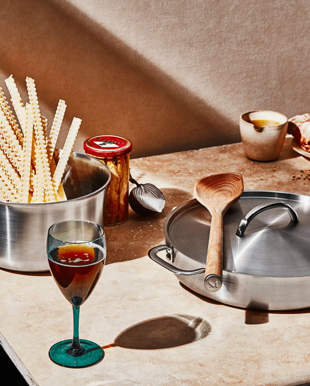 kitchen counter with pots, utensils and wine glass