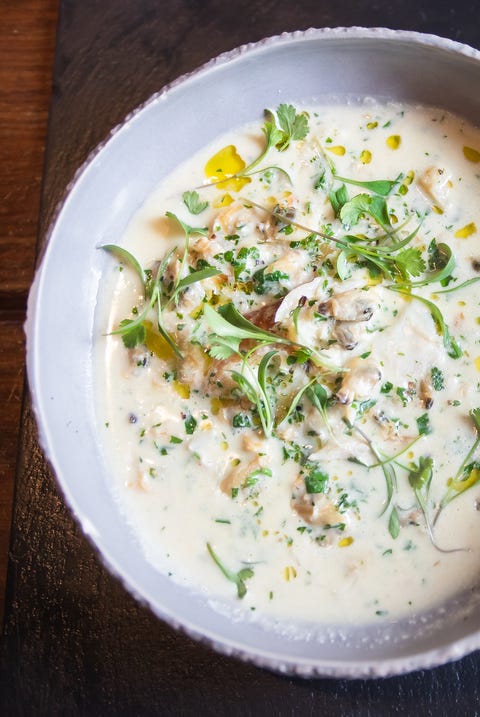 seafood chowder, corn bread and butter in a bowl on a black board