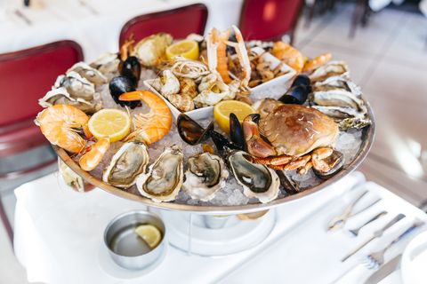 seafood plate with oysters, prawns, crab, mussels served on crushed ice in plate in a luxury restaurant
