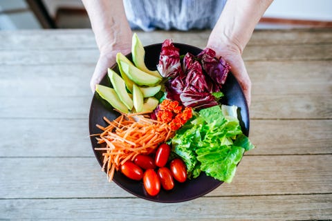 Close-up salad of avocado, lettuce, tomato and carrot held by woman's hands dieta mediterránea, la más sana y la mejor para adelgazar