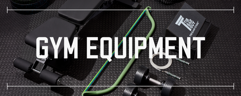 various pieces of gym equipment laid out on black rubber gym flooring with text saying gym equipment laid over top the photo