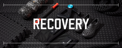 multiple pieces of fitness recovery gear in various colors laid out on black rubber gym flooring with text saying recovery laid over top the photo