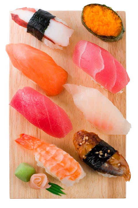 Selection of sushi and sashimi on a wooden board Selection of sushi and sashimi on a wooden board