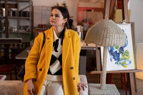 selena gomez wears a yellow coat and argyle sweater on the set of only murders in the building
