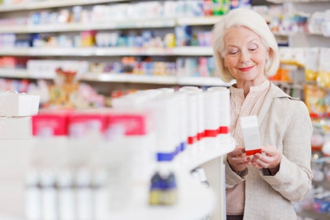 Senior woman reading package in drug store