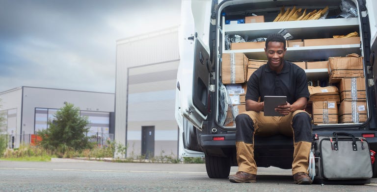 service engineer sat at the back of his van