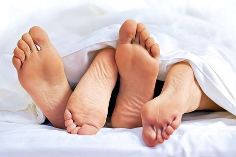 Close-up of the feet of a couple on the bed