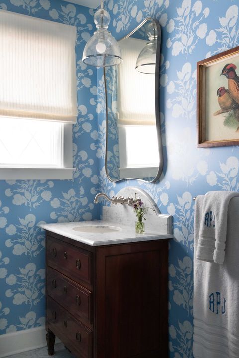 powder room, blue and white wallpaper, brown dresser as vanity with marble countertop, monogrammed towels