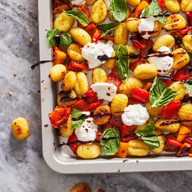 gnocchi, burrata, tomatoes, and basil drizzled with balsamic reduction on a sheet pan