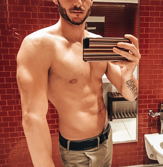 shirtless man take a selfie inside the bathroom