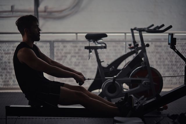 shot of a handsome young man sitting and using a rowing machine during his workout in the gym