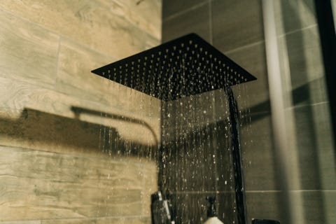 shower head in bathroom with water drops flowing