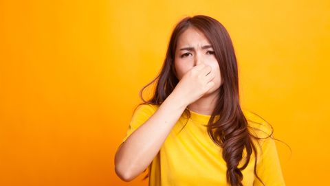 een meisje knijpt haar neus dicht vanwege een onaangename geur