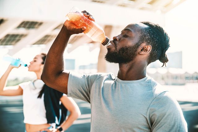 athlete drinking energy drink outdoor