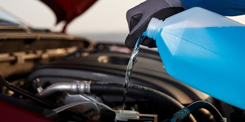 Pouring antifreeze into car