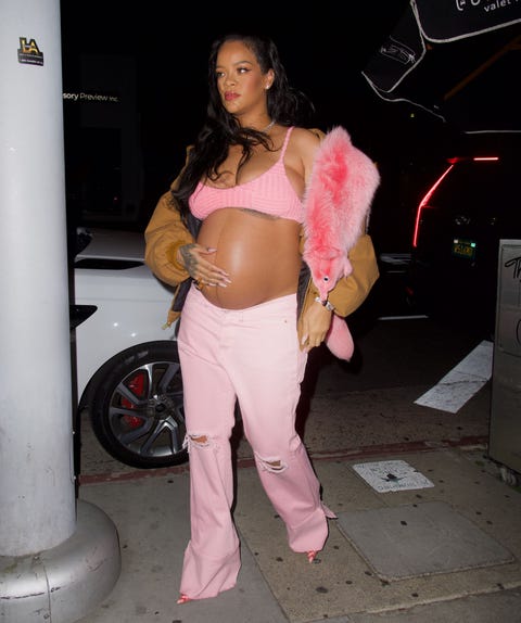 mandatory credit photo by diggzyshutterstock 12891363q  rihanna wore a pink faux fox across her shoulder as she arrived at the nice guy in hollywood she wore a pink bra top and a construction jacket as she made her way inside, gently cradling her growing baby bump  rihanna gently cradles her baby bump as she arrives at the nice guy to celebrate her bff melissa fordes birthday, los angeles, california, usa   12 apr 2022  wearing r13, jacket, wearing bottega veneta, top, wearing vetements, jeans