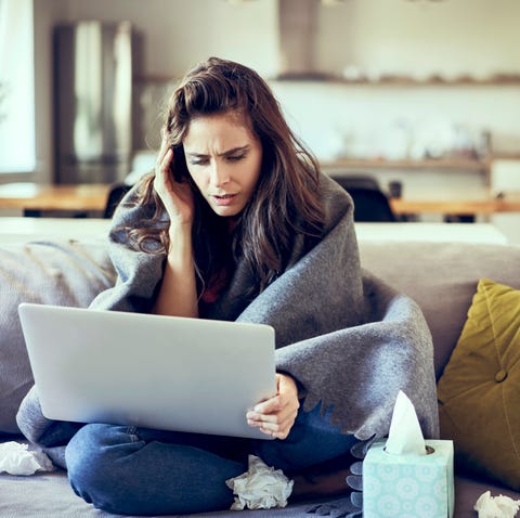 Sick woman trying to work from home on laptop