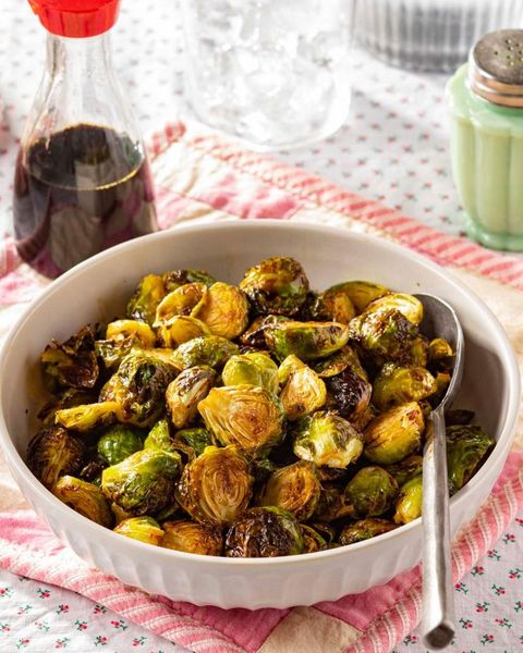 air fryer brussels sprouts in white bowl with soy sauce