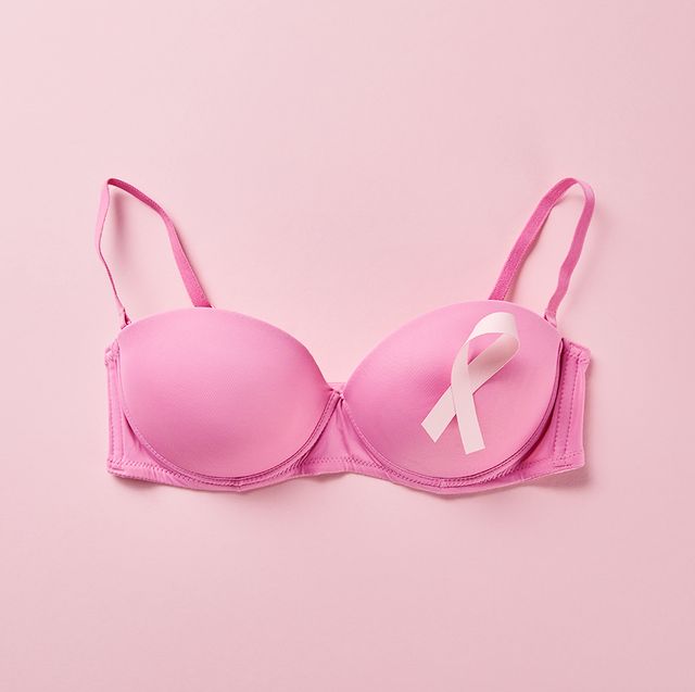 top view of ribbon on brassiere on pink background, breast cancer concept