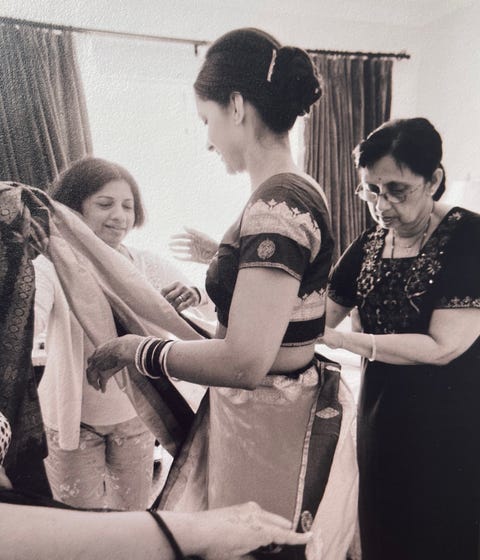 the author is helped into her wedding sari by two older women