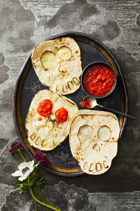 skull shaped quesadillas with red salsa on the side