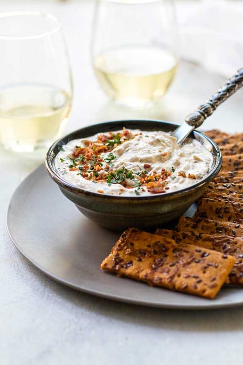 slow cooker dips caramelized onion dip with crackers and wine glasses in back