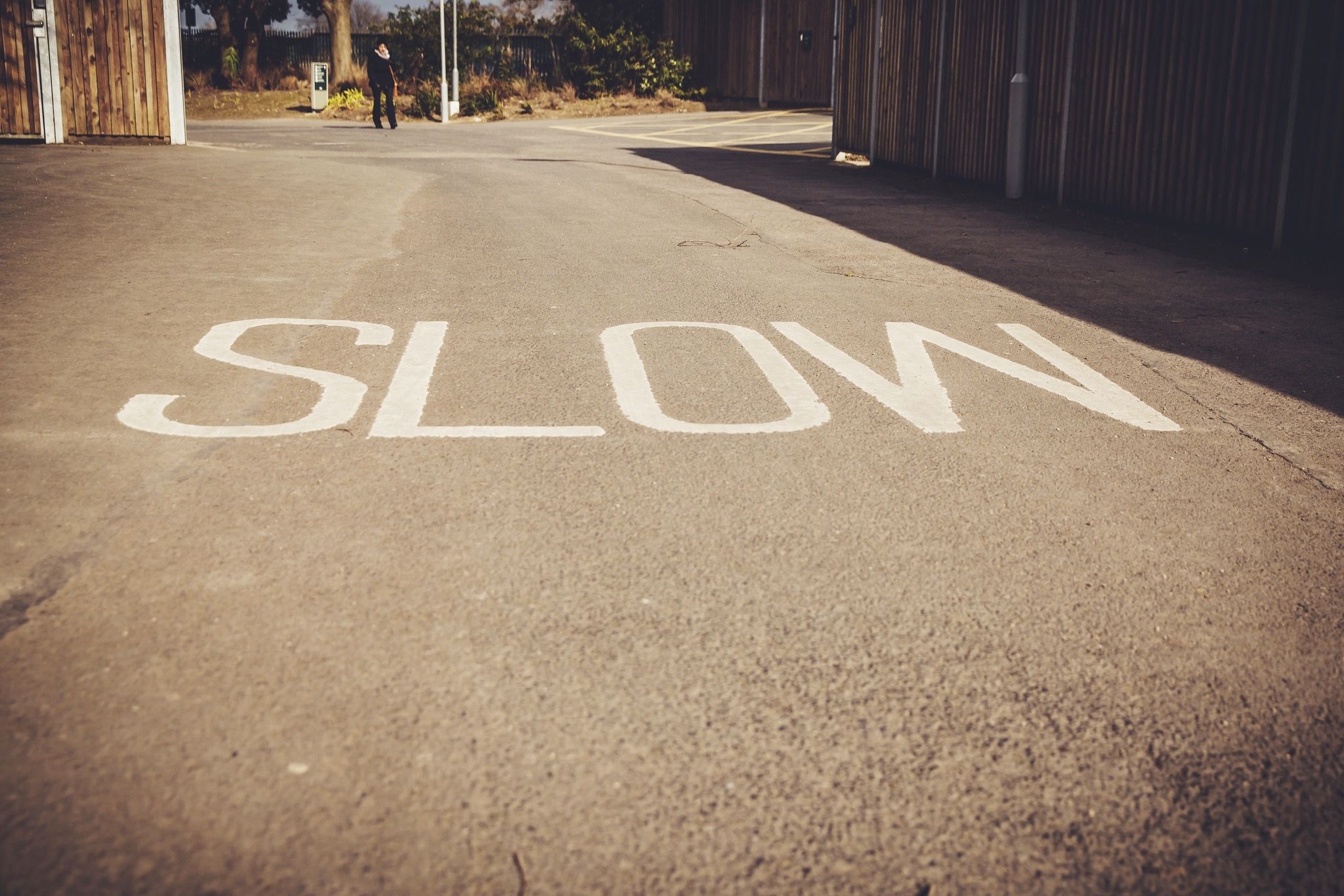 Slow down painted on Road. See you on the Road. Slow Roads. Slow. Slow meaning