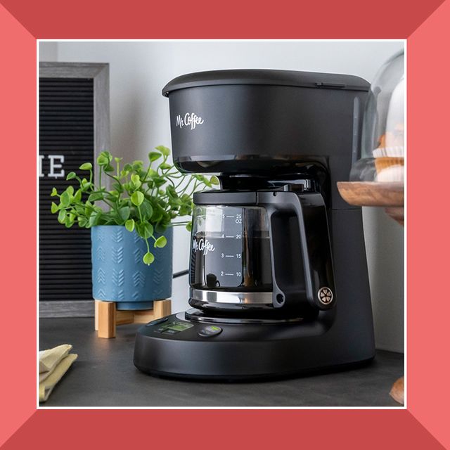 person pushing down aeropress cofee maker and small mr coffee maker maker on countertop with plant