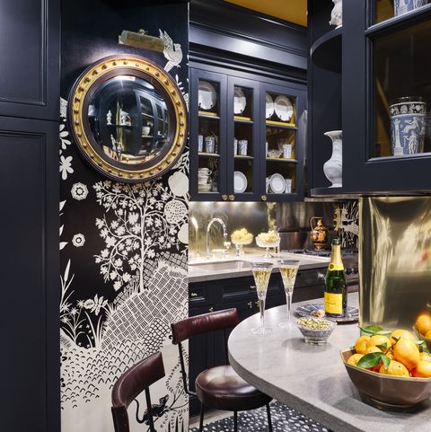 manhattan apartment of garrow kedigian in the legendary carlyle hotel a 19th century butler’s mirror offers a peek into the kitchen and its brass sheet backsplash leather stools, le forge wallpaper, christian lacroix