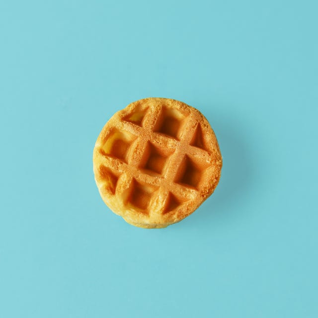 Small round Belgian waffle on trendy blue background small round belgian waffle on trendy blue background