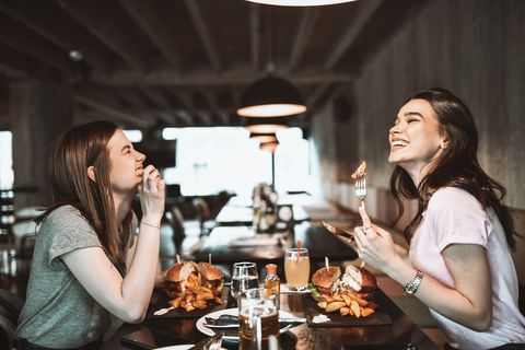 smiling females enjoying delicious food at restaurant