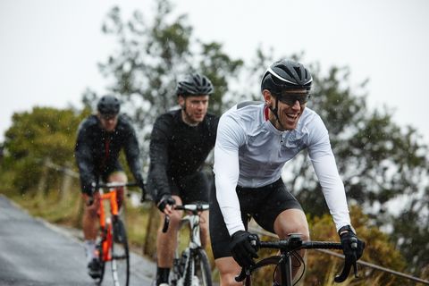 Smiling male cyclist cycling with friends