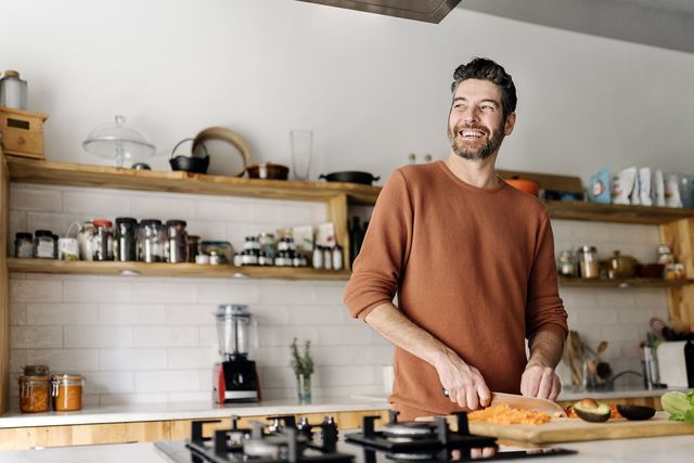 smiling man standing in kitchen at home