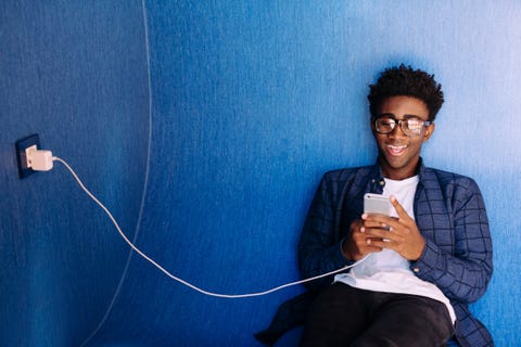 Smiling man using mobile phone while sitting in library