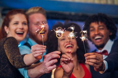 smiling people holding sparklers
