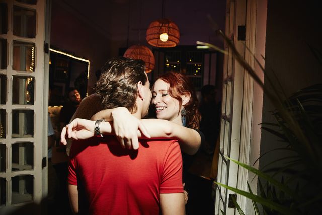 smiling woman embracing boyfriend during party in night club