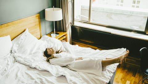 een vrouw ligt op een bed in een hotel