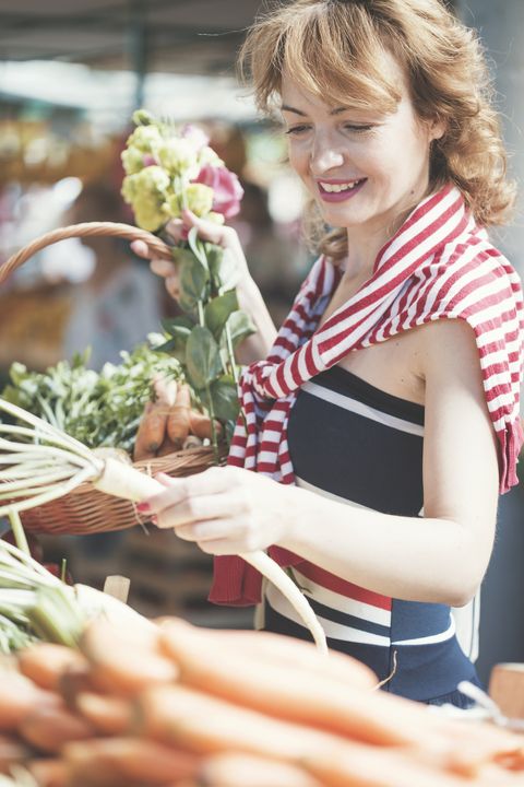 smiling woman shopping vegetables on farmer's market
